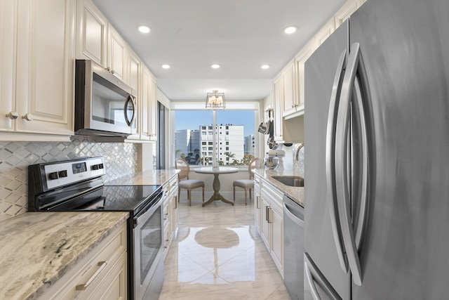 kitchen with sink, stainless steel appliances, light stone counters, tasteful backsplash, and pendant lighting