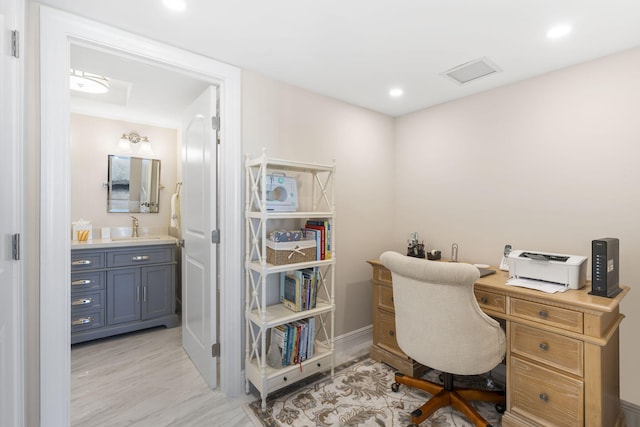 office with sink and light hardwood / wood-style flooring