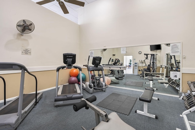 exercise room with high vaulted ceiling, ceiling fan, and carpet floors