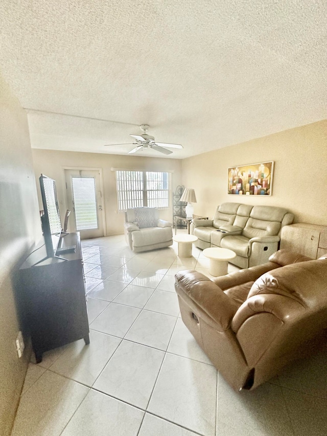 living room with light tile flooring, ceiling fan, and a textured ceiling