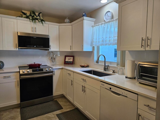 kitchen with tasteful backsplash, light tile flooring, appliances with stainless steel finishes, and sink