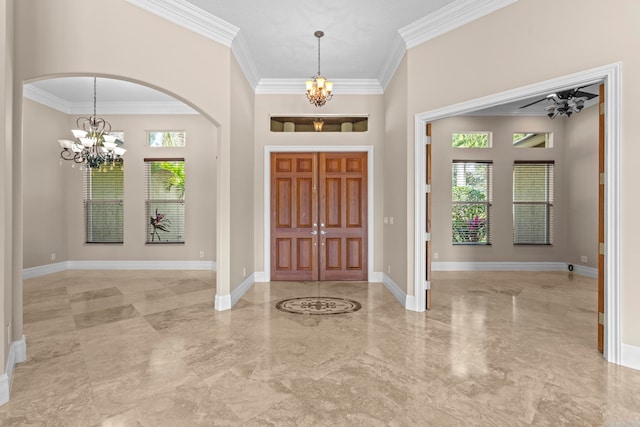 tiled foyer featuring plenty of natural light, crown molding, and ceiling fan with notable chandelier