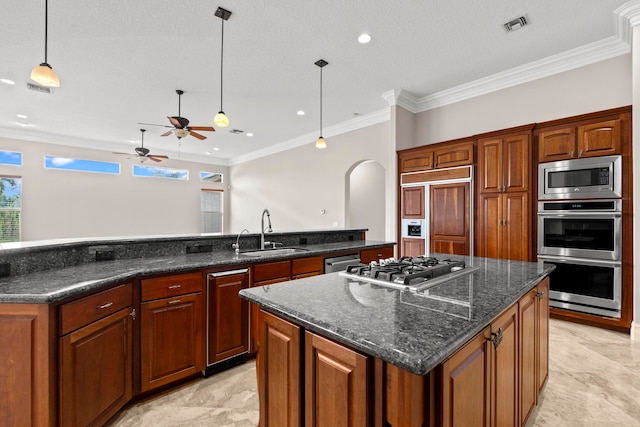 kitchen featuring a center island, ceiling fan, sink, and built in appliances