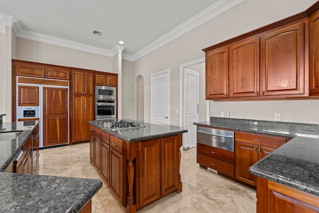 kitchen featuring built in appliances, light tile floors, crown molding, dark stone countertops, and a center island