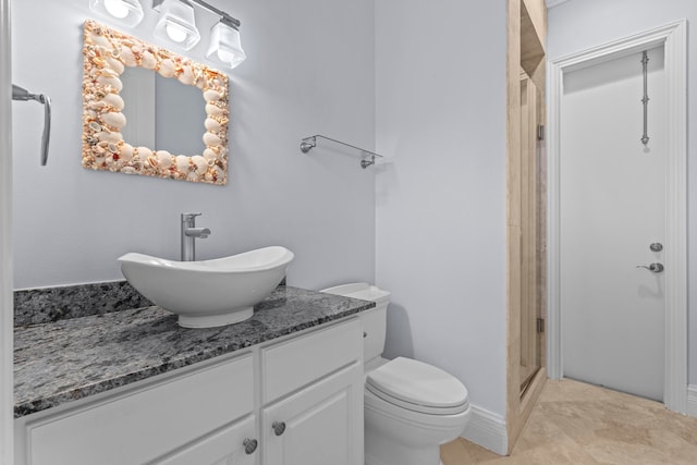 bathroom featuring toilet, vanity, a shower with door, and tile flooring