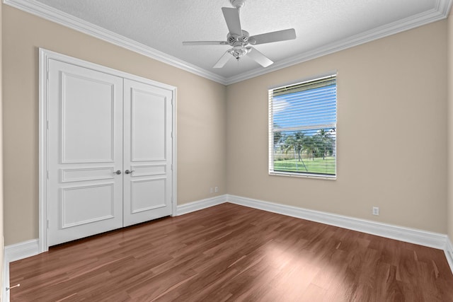 unfurnished bedroom featuring ornamental molding, a closet, ceiling fan, and dark hardwood / wood-style floors