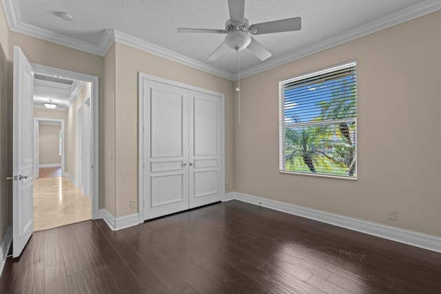 unfurnished bedroom featuring a closet, ornamental molding, ceiling fan, and dark hardwood / wood-style flooring