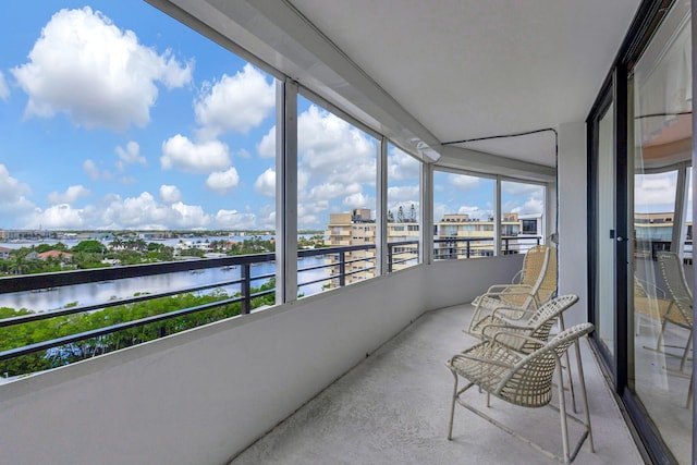 sunroom featuring a water view