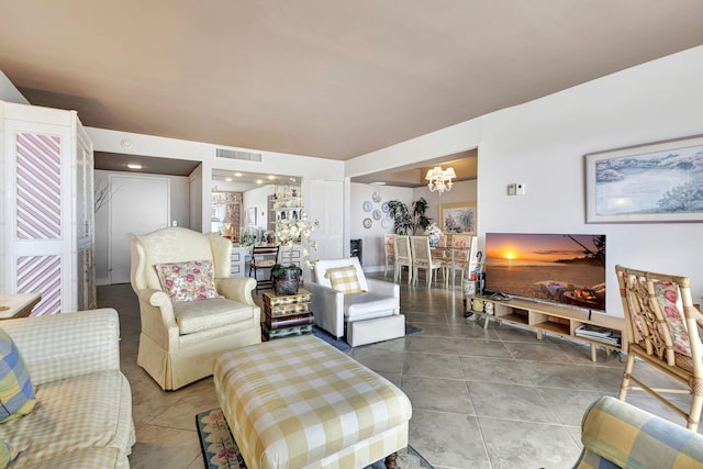 tiled living room with a notable chandelier