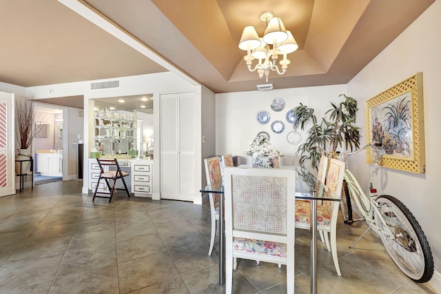 dining room featuring a chandelier and a raised ceiling