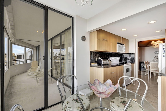 kitchen with tasteful backsplash, a chandelier, white appliances, and light tile patterned floors