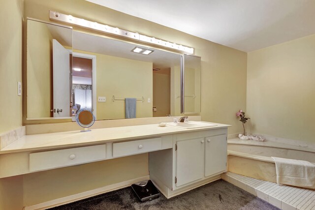 bathroom with a tub to relax in and vanity