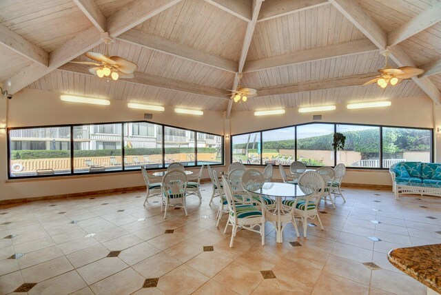 unfurnished sunroom featuring a healthy amount of sunlight, wooden ceiling, and ceiling fan