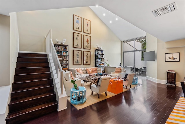 living room with dark wood-type flooring and high vaulted ceiling