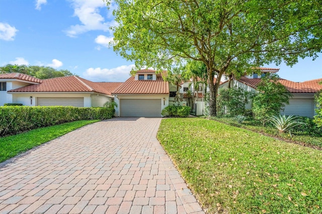 mediterranean / spanish-style home with a front yard and a garage