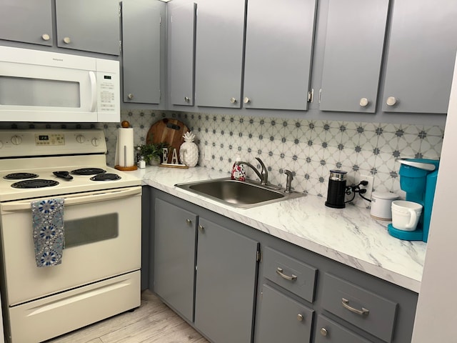 kitchen featuring backsplash, white appliances, sink, and gray cabinets