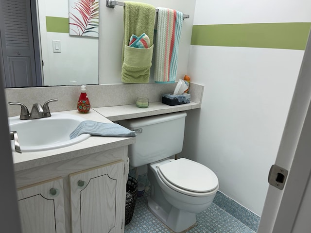 bathroom featuring toilet, tile flooring, and vanity