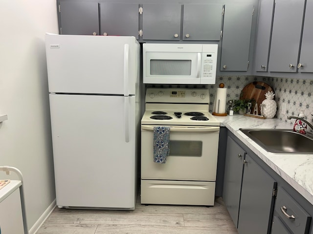 kitchen featuring gray cabinetry, backsplash, white appliances, and sink