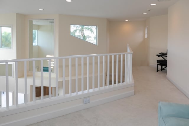 hallway featuring a wealth of natural light and carpet