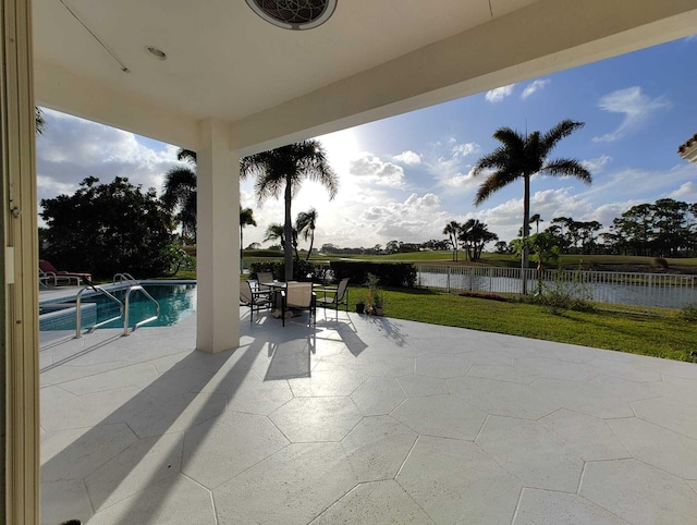 view of patio / terrace featuring a fenced in pool and a water view