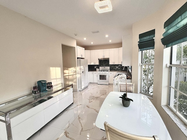 kitchen featuring white cabinets, white appliances, and decorative backsplash