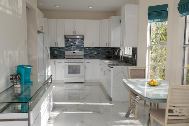 kitchen with backsplash, white appliances, sink, and white cabinets