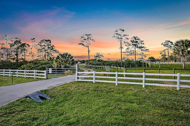 yard at dusk featuring a rural view