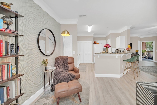 sitting room featuring light hardwood / wood-style flooring and crown molding