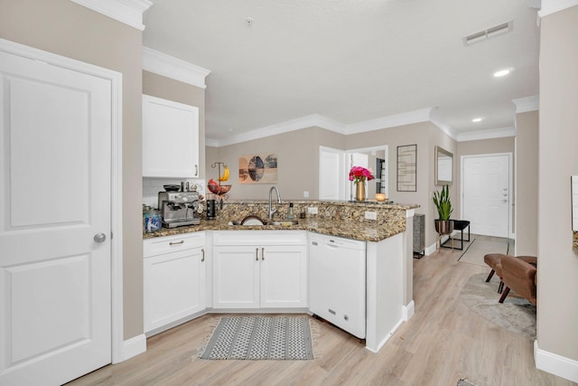 kitchen with light hardwood / wood-style floors, sink, dark stone counters, and white dishwasher