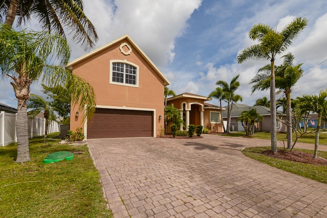 mediterranean / spanish-style home with a front lawn and a garage