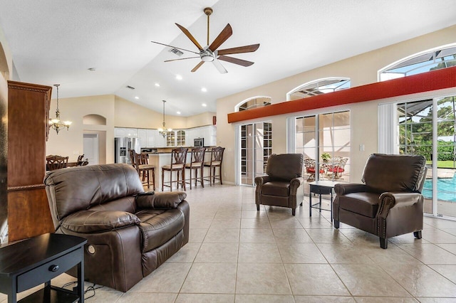 living room featuring light tile patterned floors, ceiling fan with notable chandelier, high vaulted ceiling, and a textured ceiling