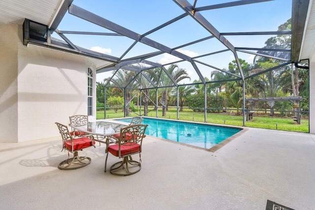 view of pool with glass enclosure, a patio area, and a yard