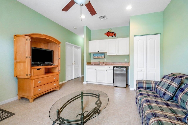 living room with ceiling fan, a textured ceiling, and light tile patterned flooring