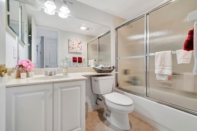 full bathroom with bath / shower combo with glass door, vanity, toilet, and tile patterned floors