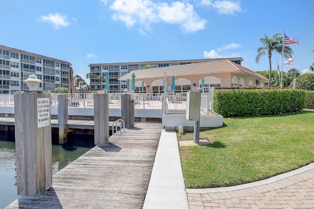 dock area with a water view and a yard