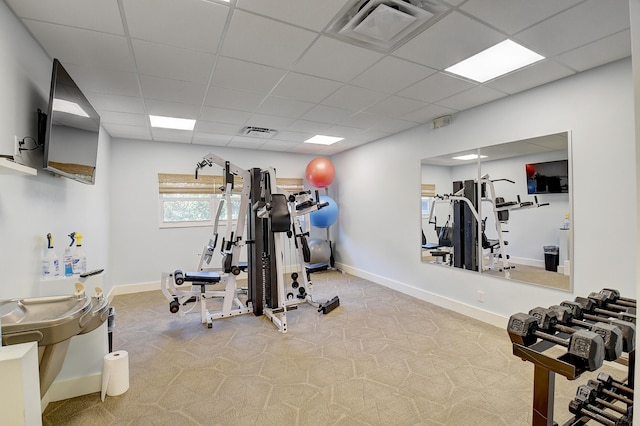 workout room featuring carpet floors and a paneled ceiling