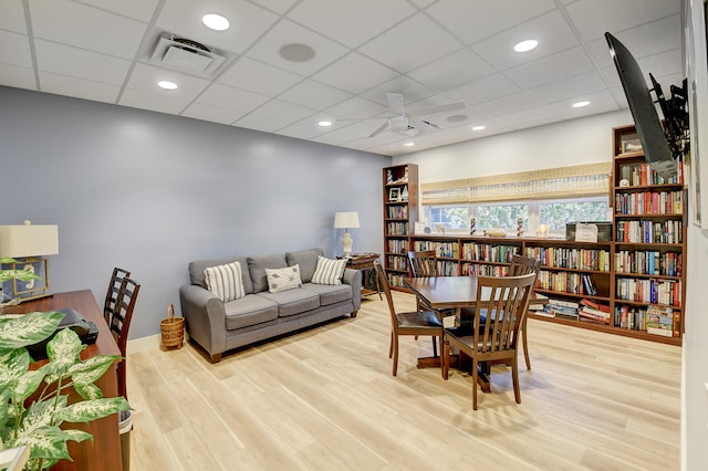 living room featuring ceiling fan, a paneled ceiling, and light hardwood / wood-style floors