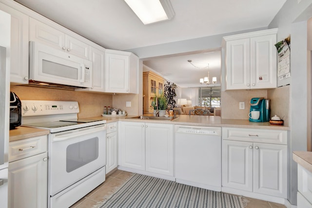 kitchen featuring white appliances, light tile patterned flooring, an inviting chandelier, and white cabinets