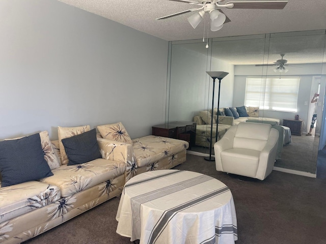 living room featuring a textured ceiling, ceiling fan, and dark colored carpet