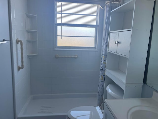 bathroom with toilet, a shower with shower curtain, and vanity