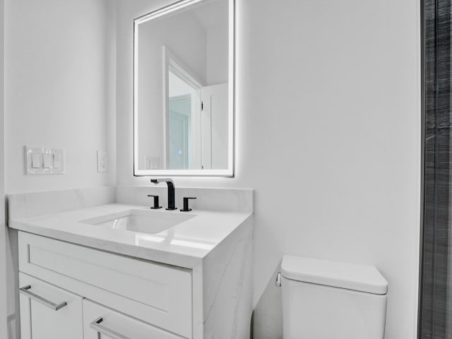 bathroom with toilet and vanity with extensive cabinet space