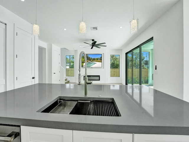 kitchen with white cabinets, ceiling fan, and pendant lighting