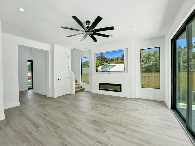 unfurnished living room featuring a healthy amount of sunlight, light hardwood / wood-style floors, and ceiling fan