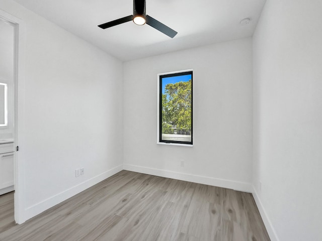 spare room with ceiling fan and light wood-type flooring