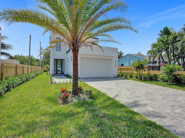 view of front of home with a front yard and a garage