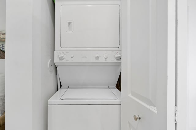 washroom featuring stacked washer / drying machine