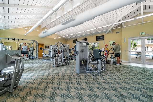 exercise room featuring french doors, a towering ceiling, a healthy amount of sunlight, and carpet