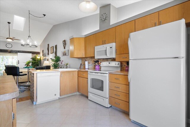 kitchen featuring decorative light fixtures, an inviting chandelier, high vaulted ceiling, white appliances, and light tile floors