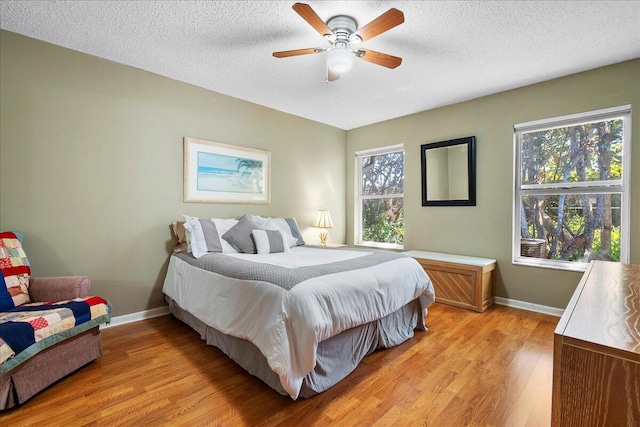 bedroom featuring multiple windows, light wood-type flooring, and ceiling fan