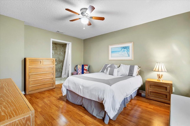 bedroom featuring a textured ceiling, ceiling fan, and light wood-type flooring